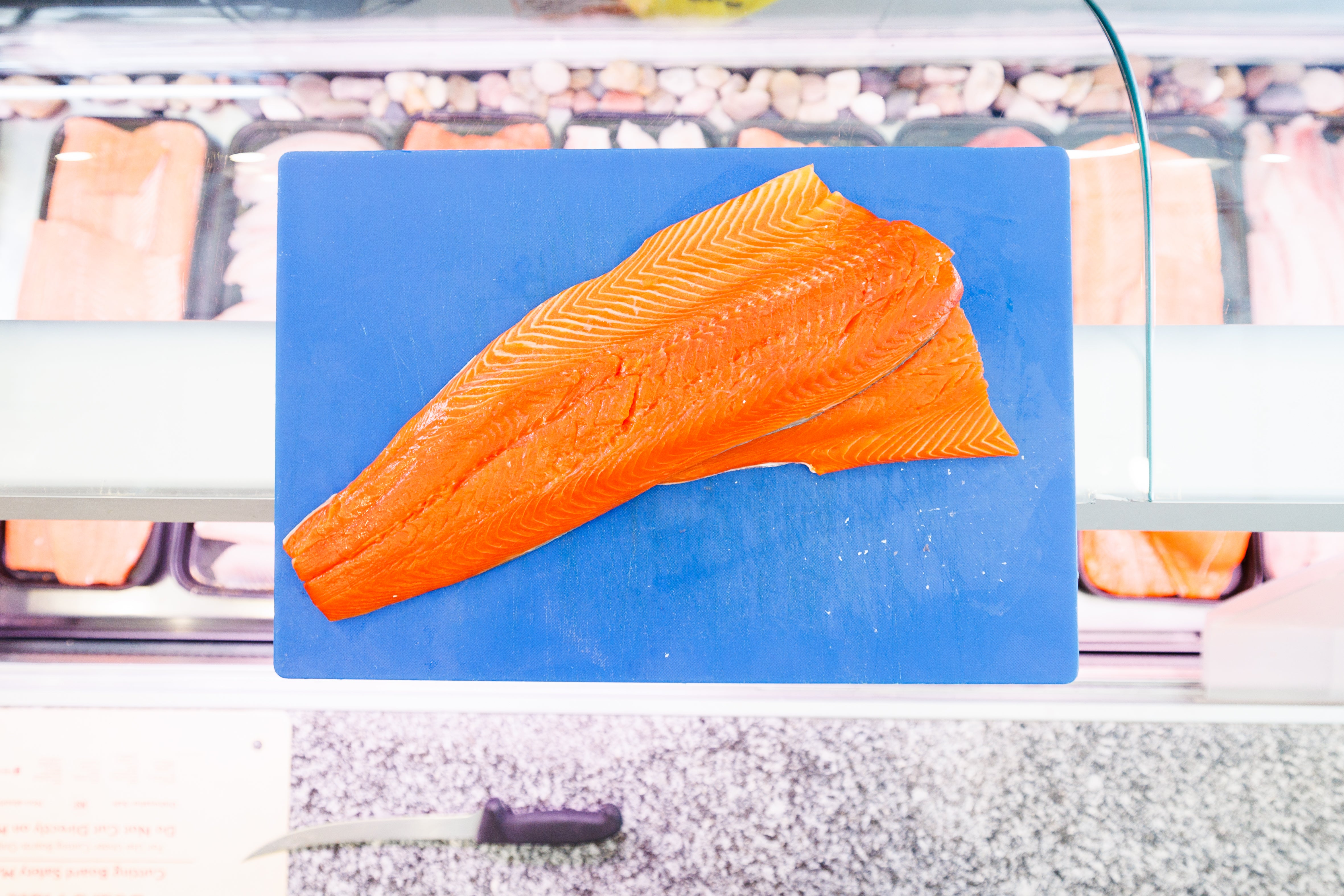 A fillet of Atlantic Salmon on a blue cutting board
