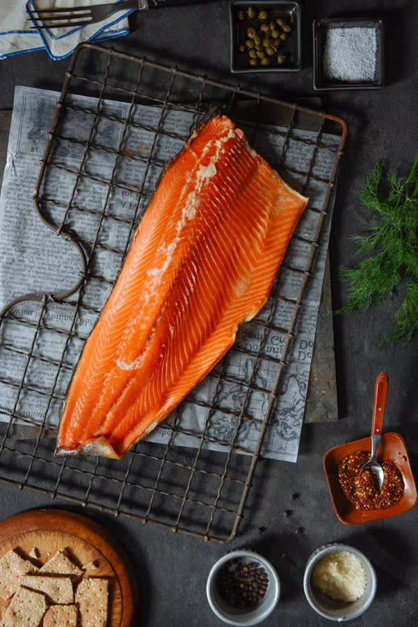 A piece of smoked steelhead trout, surrounded by garnish.