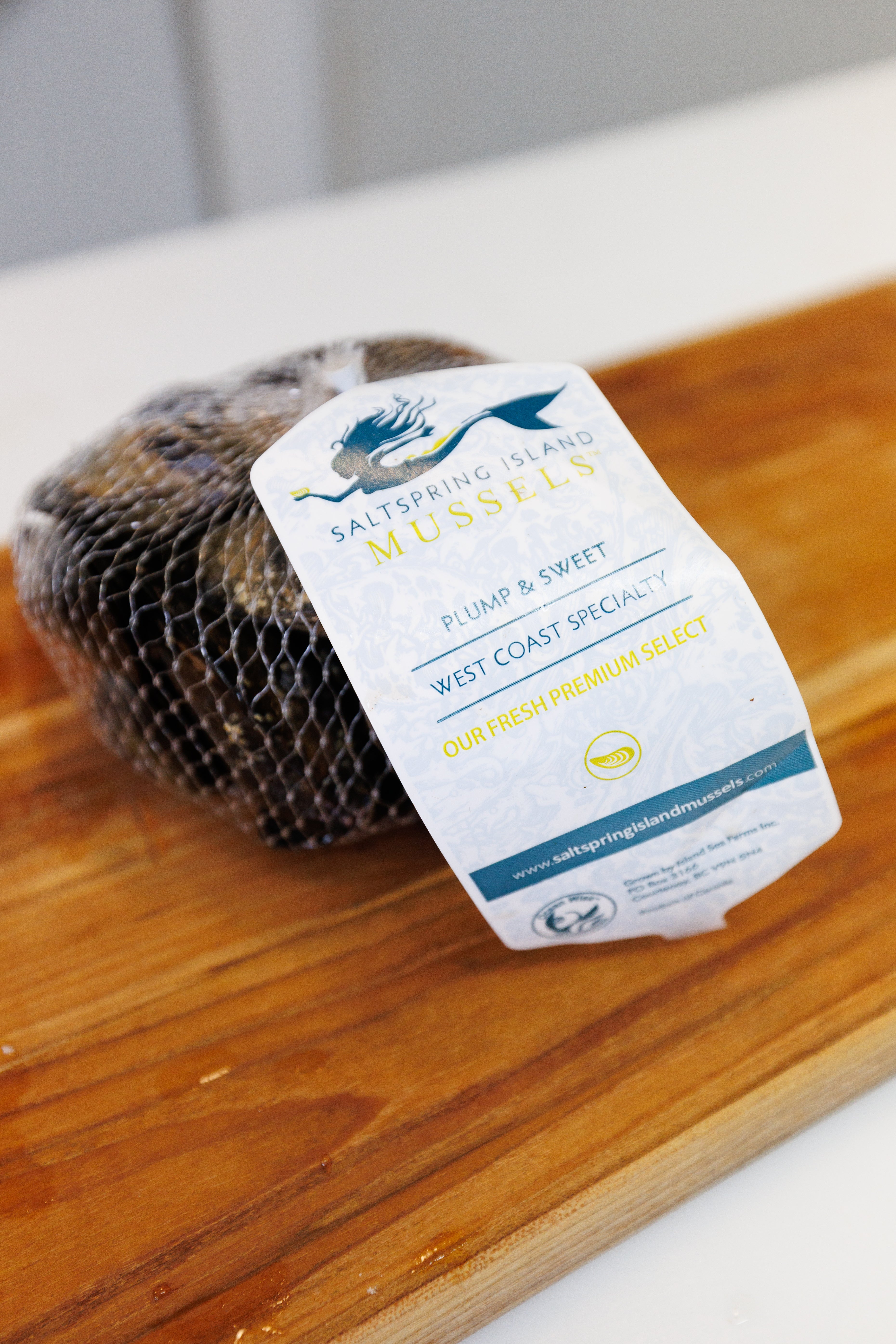 A package of fresh Saltspring Island Mussels. The tag reads "plump and sweet; west coast specialty; our fresh premium select"