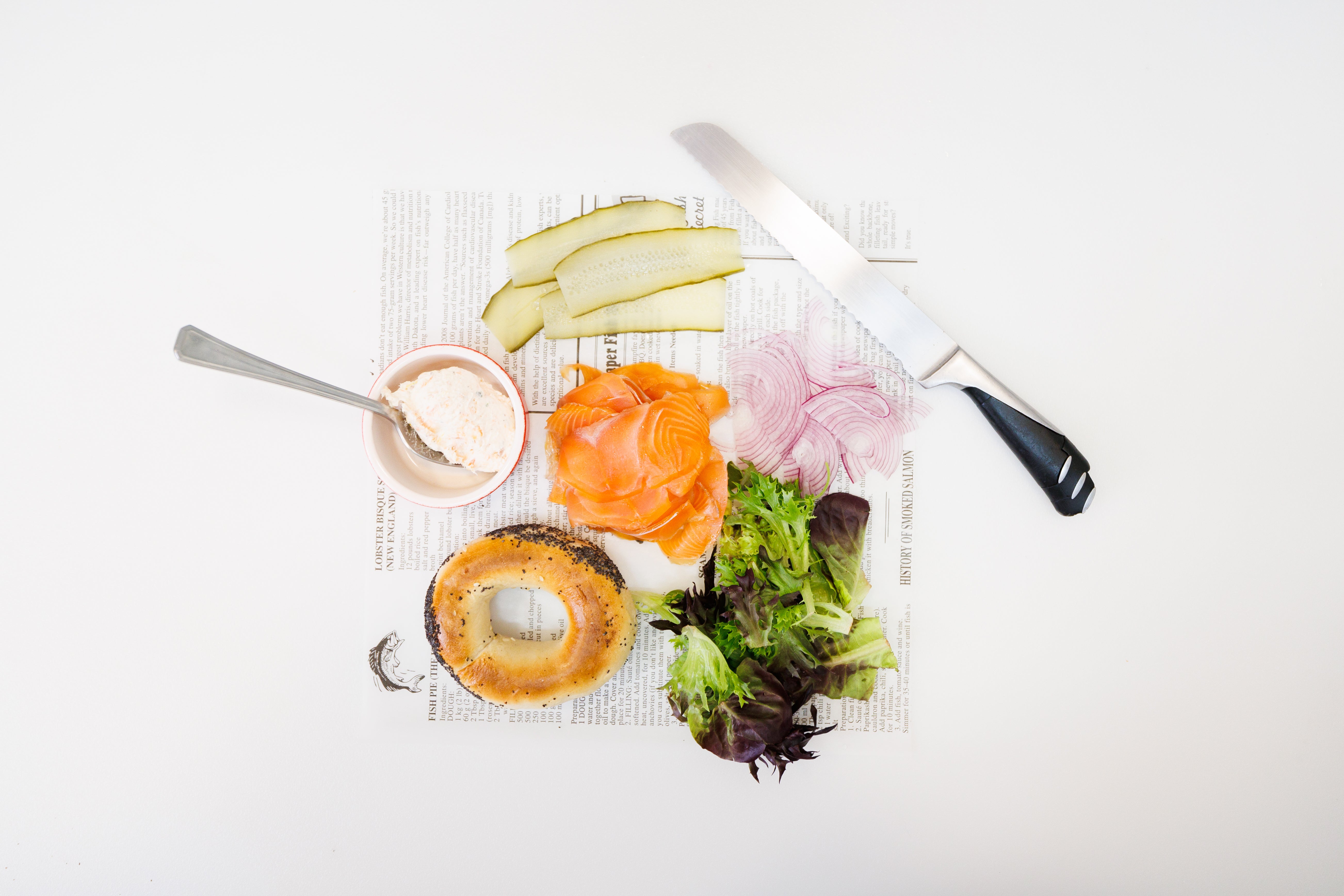 Slices of cold smoked salmon surrounded by garnish ingredients for a sandwich